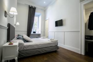 una camera da letto con un letto e una TV a parete di Relais della Torre a Roma Altre 45 foto