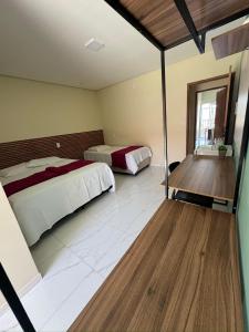 a large bedroom with two beds and a window at Pousada Vila das Lagoas in Santo Amaro
