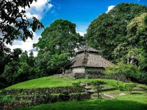 an old building on a hill with green grass at Pondok Sedi Bungalow in Labuhancari