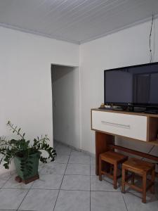 un soggiorno con TV a schermo piatto su un tavolo di Apartamento bem localizado em Diamantina-MG a Diamantina