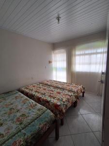 due letti in una stanza con una finestra di Apartamento bem localizado em Diamantina-MG a Diamantina
