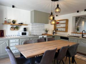 a kitchen with a wooden table and chairs at Villa Mer - Large luxury family holiday home Ziltwater in Cadzand
