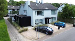 a blue car parked in front of a house at Villa Mer - Large luxury family holiday home Ziltwater in Cadzand