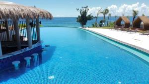 a swimming pool with a view of the ocean at Flow 8 Suites at Mactan Newtown in Punta Engaño