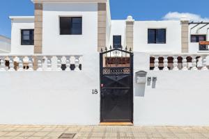 una puerta negra en un lado de un edificio blanco en Habitaciónes cerca de la playa y del aeropuerto en una casa familiar, en Playa Honda