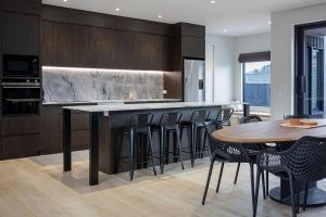 eine Küche mit einer Bar mit Stühlen und einem Tisch in der Unterkunft NEW! The Black Box - 3 Bedroom Sanctuary in Methven