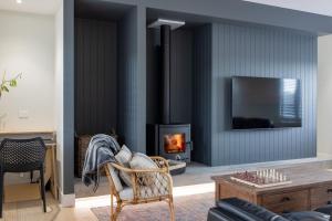 ein Wohnzimmer mit Kamin und Sessel in der Unterkunft NEW! The Black Box - 3 Bedroom Sanctuary in Methven