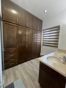 a bathroom with a sink and wooden cabinets at Lucardo 5 ESTRELAS PARA VIVIR LA PAZ in La Paz +20 photos
