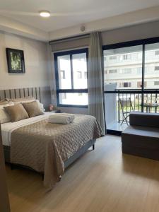 ein Schlafzimmer mit einem Bett und einem großen Fenster in der Unterkunft Studio 206 - Para ate 4 Pessoas Próx ao Allianz Parque in São Paulo