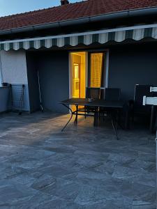 a patio with a table and a yellow door at Apartman Nada in Biograd na Moru