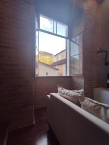 a living room with a couch and a window at Loft Encantador na Cidade Imperial in Petrópolis
