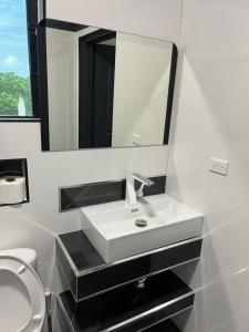 a bathroom with a white sink and a mirror at Home Away From Home in Four Paths +14 photos