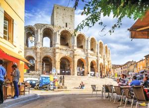 a building with people sitting in chairs in front of it at Maison avec patio in Arles