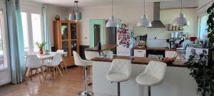 a kitchen with white chairs and a table in it at Maison avec patio in Arles