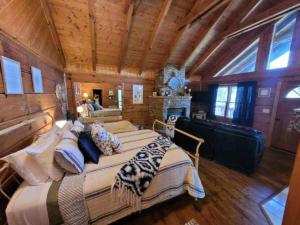 a large bedroom with a large bed and a fireplace at View Location Studio Log Cabin Hot Tub Fireplace in Pigeon Forge +25 photos