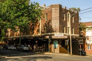 an old brick building on a street corner with a store at Darlo Bar Darlinghurst in Sydney