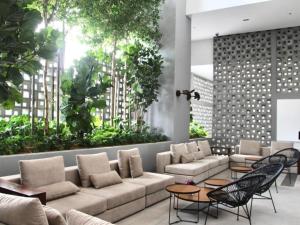 a lobby with a couch and chairs and plants at Cozy unit- Bell suites- Horizon Suites- Wifi- Netflix- Parking Swimming Pool- Klia in Sepang