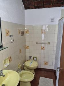 un baño con inodoro y lavabo en El Colonial Hotel, 