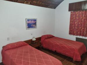 Una habitación de hotel con dos camas y una ventana. en El Colonial Hotel, 
