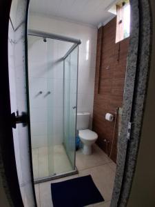 a bathroom with a glass shower and a toilet at Hotel malibu in Muriaé