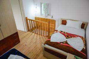 a bedroom with a bed and a wooden floor at Dikellari Guest House in Pogradec