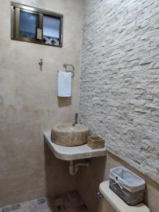 a bathroom with a sink and a stone wall at Chan Kiin Departamentos in Valladolid
