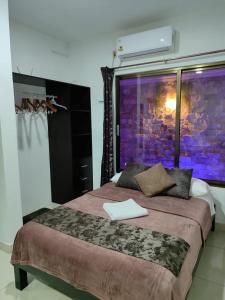 a bedroom with a large bed with a painting on the wall at Chan Kiin Departamentos in Valladolid