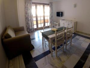 a living room with a dining room table and a couch at Apartamentos Tapahuga in Playa de Santiago