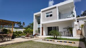 a white house with a patio and a yard at Beach House With Private Pool in Las Terrenas