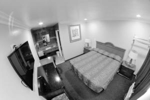 a black and white photo of a bedroom with a bed at The Palace Inn in Oxnard