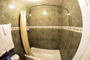 a bathroom with a shower and a toilet at The Palace Inn in Oxnard