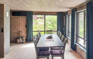 a dining room with a table and chairs and windows at Beautiful Home In Dølemo in Austenå