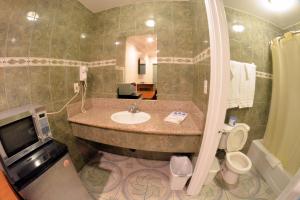 a bathroom with a sink and a toilet at The Palace Inn in Oxnard