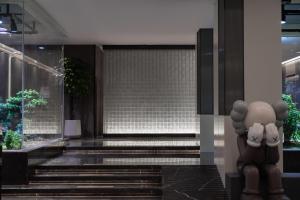 a lobby of a building with stairs and a statue at Atour Hotel Jinan Jingshidong Road Rongchuangmao in Jinan