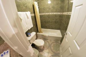 a small bathroom with a toilet and a sink at The Palace Inn in Oxnard