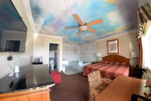 a hotel room with a bed and a ceiling at The Palace Inn in Oxnard