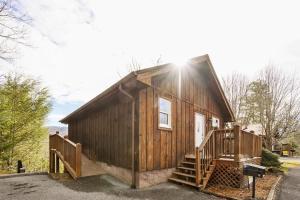 ガトリンバーグにあるGreat View Location Studio Log Cabin Hot Tubの小さな木造のキャビン(ポーチ、階段付)