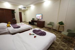Postel nebo postele na pokoji v ubytování Dunhuang Bokang Hotel + 2 fotografie