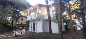 Casa blanca pequeña con mesa y sillas en Holiday home in Rosolina Mare 25059, en Rosolina Mare