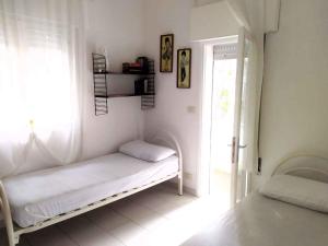 Una habitación blanca con una cama y una ventana. en Holiday home in Rosolina Mare 25059, en Rosolina Mare
