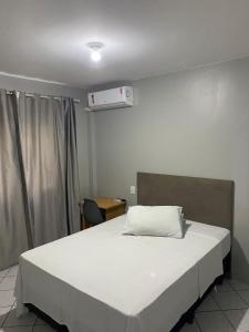 a bedroom with a large bed with a white bedsheet at Nacional Park Hotel Lages in Lages