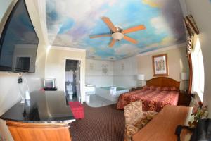 a hotel room with a bed and a ceiling at The Palace Inn in Oxnard