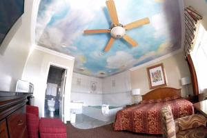 a bedroom with a ceiling with a ceiling fan at The Palace Inn in Oxnard