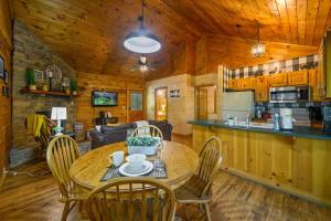 a kitchen and dining room with a table and chairs at Location Log Cabin Hot Tub Fireplace Pool Fishing in Pigeon Forge