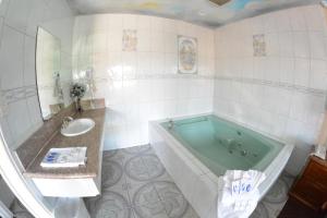 a bathroom with a tub and a sink at The Palace Inn in Oxnard