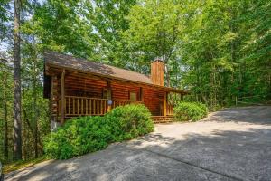 a log cabin in the woods with a driveway at Location Log Cabin Hot Tub Fireplace Pool Fishing in Pigeon Forge