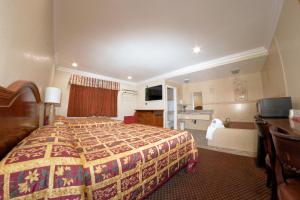 a hotel room with a bed and a living room at The Palace Inn in Oxnard
