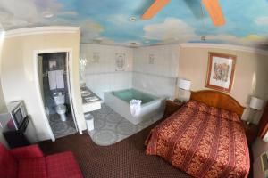 a bedroom with a bed and a bath tub at The Palace Inn in Oxnard