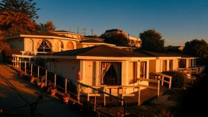 Una gran casa blanca con un porche enfrente. en Hotel Puerto Mayor, en San Antonio