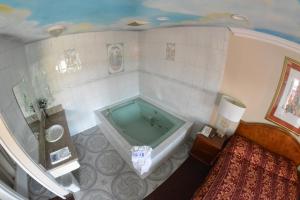 a bathroom with a tub in the corner of a room at The Palace Inn in Oxnard